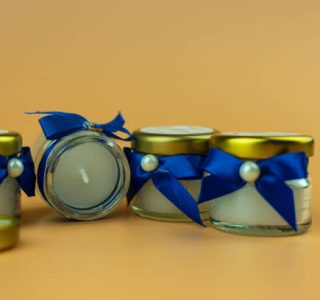 Scented candle wrapped with bow blue wedding gifts favors for guests. Close up